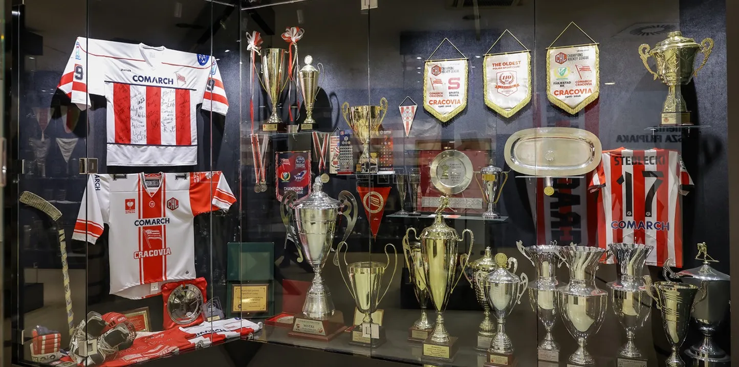Gablota z pucharami, medalami i podpisanymi koszulkami meczowymi Cracovii.